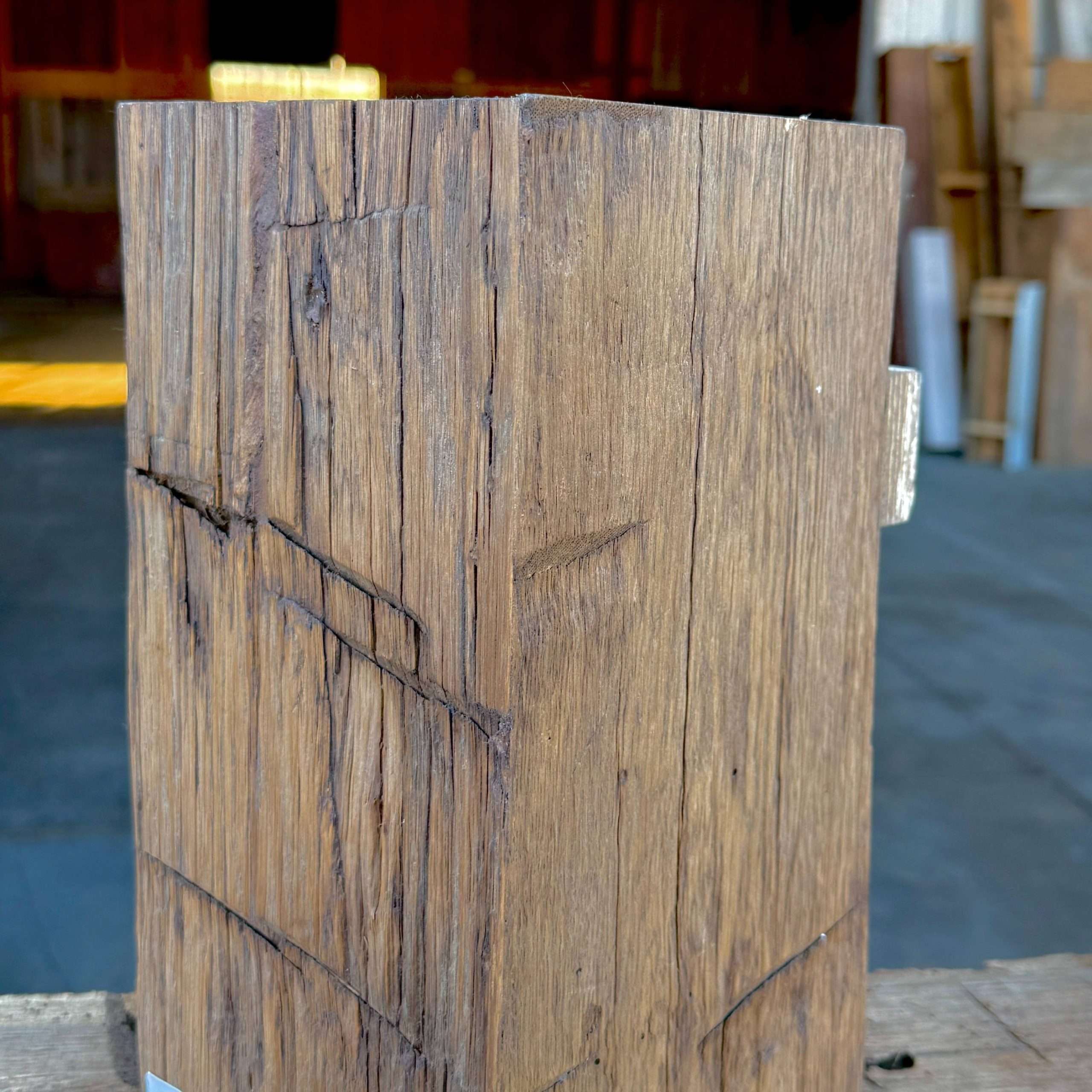 A hand-hewn Douglas fir beam with visible adze marks and dense old-growth grain.