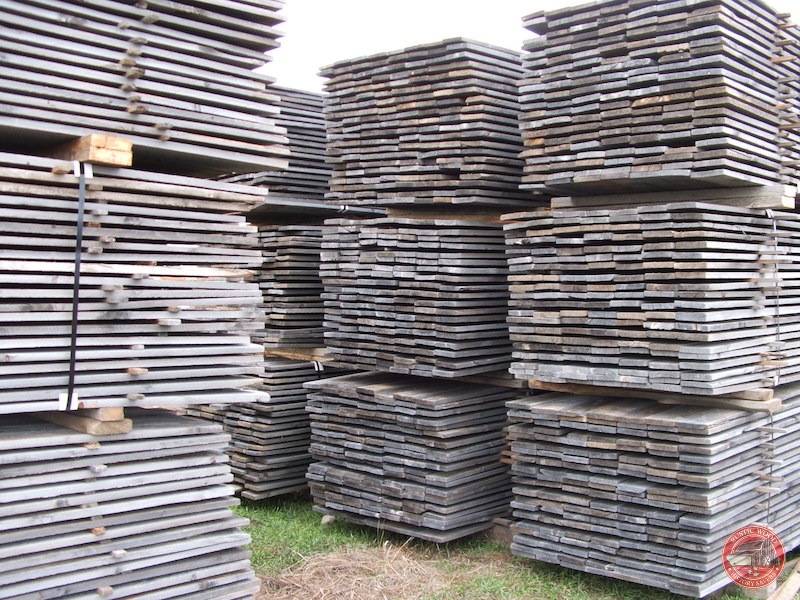 A weathered grey reclaimed snow-fence wood plank with deep checking and a silvered, wind-sanded surface.