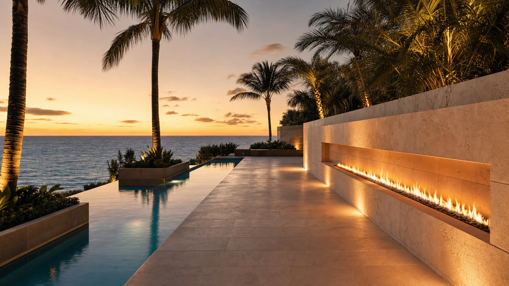 A coastal Florida terrace with cream-toned travertine pavers, deep teak loungers, and an open seaward view across dune grass to the Atlantic
